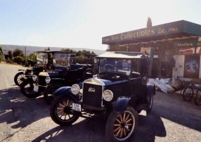 Papa Joe's Collectibles' building in the background with 3 model T Ford vehicles in front.